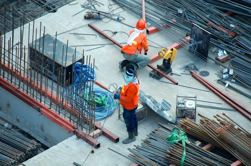 Active commercial construction site with steel framework and tower cranes