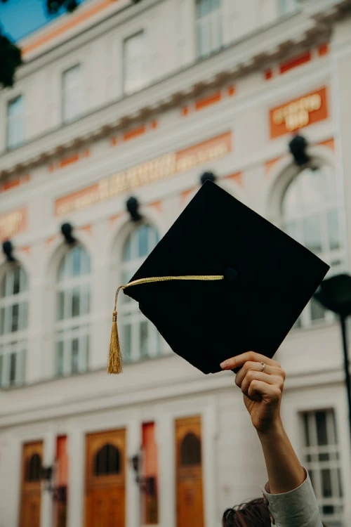Graduates in gowns celebrating at a school graduation ceremony