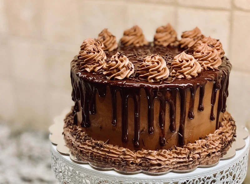 Layered chocolate cake with ganache drip on marble