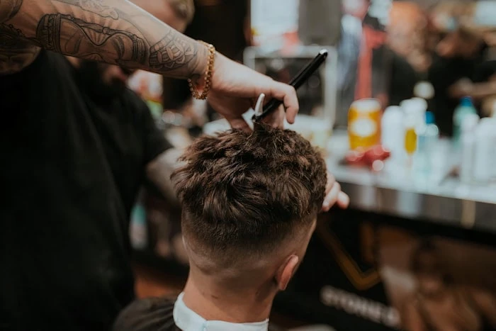 Barber sculpting a beard with careful attention to detail